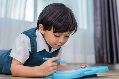 Close-up of boy studying at home