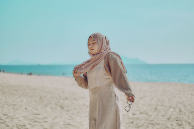 Young woman standing at beach