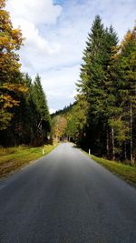 Road amidst trees against sky