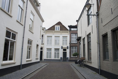 Residential buildings by street against sky