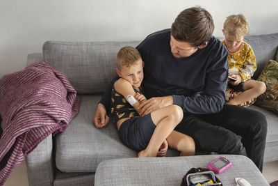 Father checking sons insulin pump