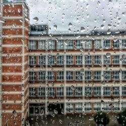 Buildings seen through wet glass window during monsoon