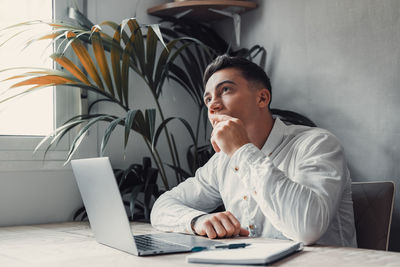 Young man using laptop at table