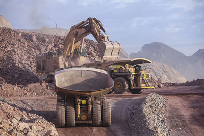 Construction site by mountains against sky