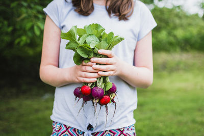 Midsection of woman holding strawberry