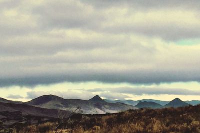 Scenic view of mountains against cloudy sky