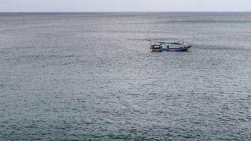 Boat sailing in sea against sky