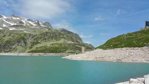 Scenic view of sea by mountains against sky