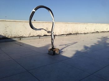 Metal structure on shore against clear blue sky