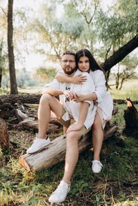 Portrait of young couple sitting on land