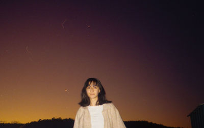 Portrait of woman standing against sky at night