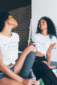 Two black women drinking coca cola in their kitchen