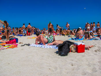 People at beach against clear sky