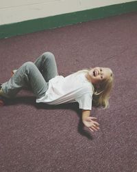 High angle view of girl laughing while lying on street