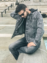 Midsection of man sitting outdoors