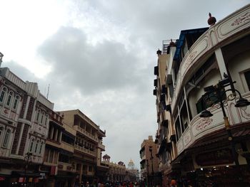 Low angle view of buildings against cloudy sky
