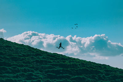 Airplane flying over mountain against sky