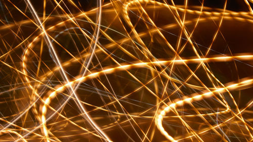 Abstract image of illuminated lights against sky at night