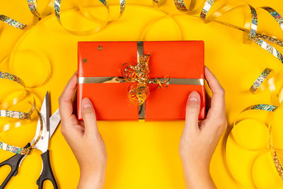 Low section of woman holding yellow dress