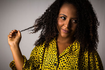 Portrait of a smiling young woman against gray background