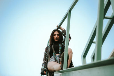 Portrait of woman sitting against clear sky