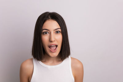 Portrait of young woman against white background