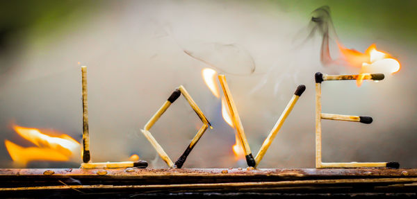 Close-up of love text made from burning matchsticks