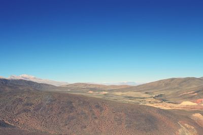 Scenic view of mountains against clear blue sky