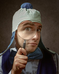Portrait of man holding magnifying glass