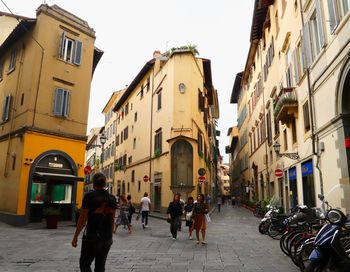 People walking on street amidst buildings in city