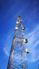 Low angle view of communications tower against blue sky