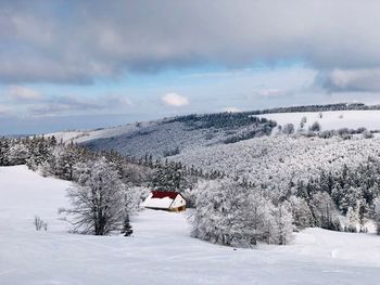 Lonely house in the mountains surrounded by forest covered in snow