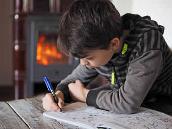 Full length portrait of boy sitting on table