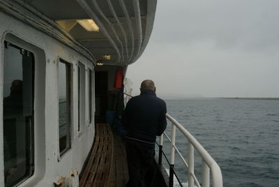 Rear view of man looking at sea against sky
