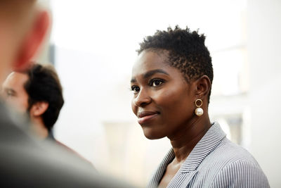 Smiling businesswoman looking at male colleague in office