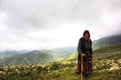 Portrait of senior woman on mountain against sky