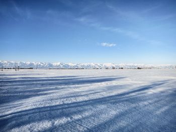 Scenic view of snow covered mountain against blue sky