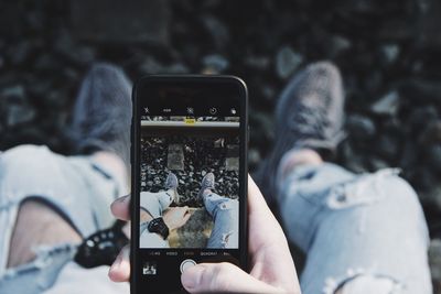 Midsection of woman photographing with mobile phone