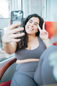 Young woman using mobile phone while sitting in car