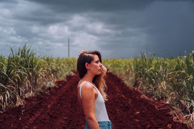 Woman standing on field against sky