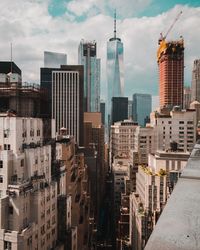 One world trade centre and other buildings in city against sky and street 