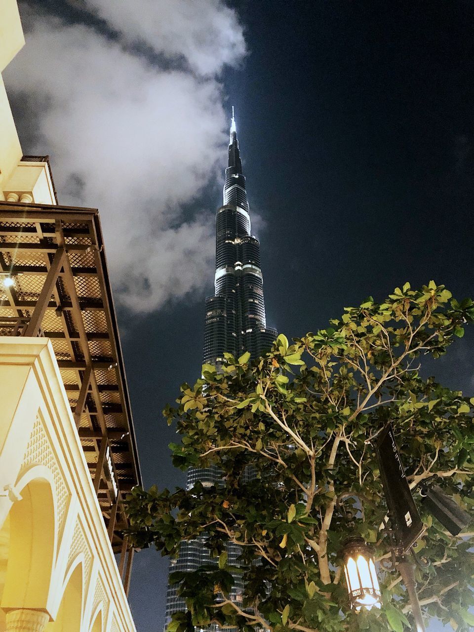 LOW ANGLE VIEW OF ILLUMINATED BUILDINGS IN CITY AGAINST SKY