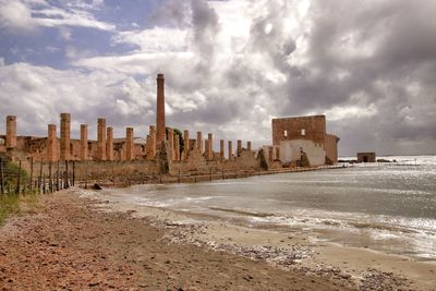 Buildings by sea against sky in city