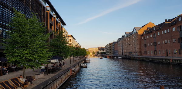 Canal amidst buildings in city against sky