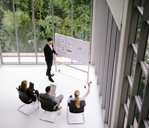 High angle view of businessman giving presentation to colleagues in office