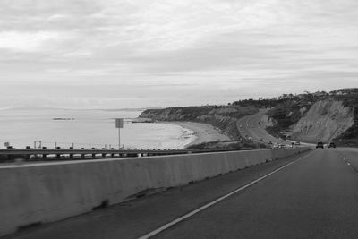 Road by sea against sky in city