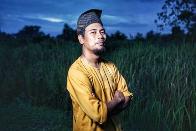 Portrait of mid adult man standing at farm during dusk