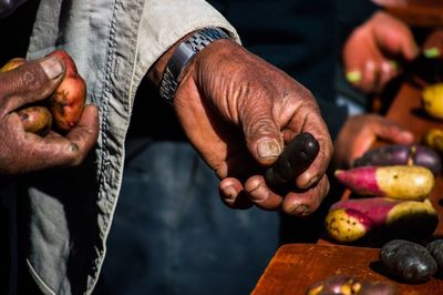 Midsection of man holding fruit