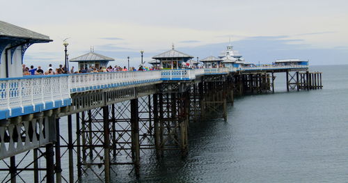 Pier over sea and buildings against sky