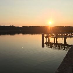 Silhouette pier on lake against sky during sunset